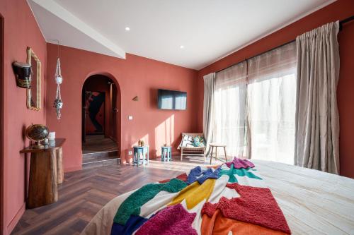 a bedroom with red walls and a bed with colorful blankets at The Music Suites in Bruges