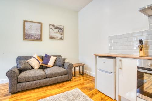 a living room with a couch and a kitchen at Superb City Center 2 Bed Apartment Free Wifi in Lincoln