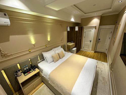 a bedroom with a large white bed in a room at Qadim Hotel in Samarkand