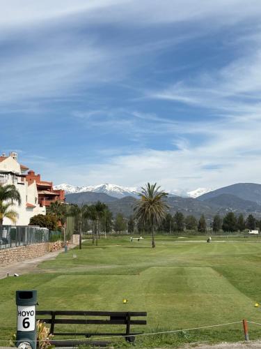 Blick auf einen Golfplatz mit Bergen im Hintergrund in der Unterkunft Beach Apartment Tropical Golf in Motril