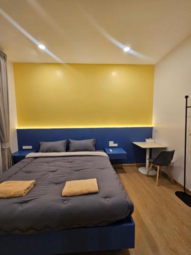 ein Schlafzimmer mit einem Bett und einer gelben Wand in der Unterkunft บ้านเราเอง My House Khaoyai in Pak Chong