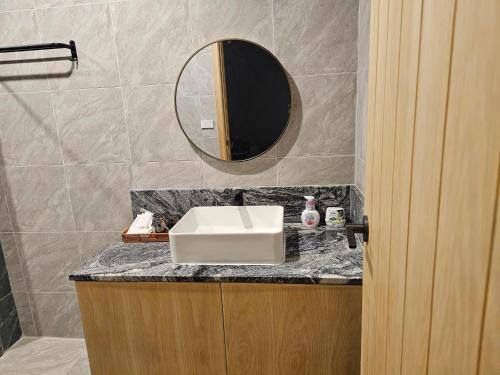 ein Badezimmer mit einem Waschbecken und einem Spiegel auf einer Ablage in der Unterkunft บ้านเราเอง My House Khaoyai in Pak Chong