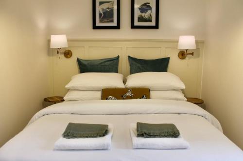 une chambre avec un grand lit blanc avec deux oreillers dans l'établissement Cosy Cottage in Rural Lympsham, à Lympsham