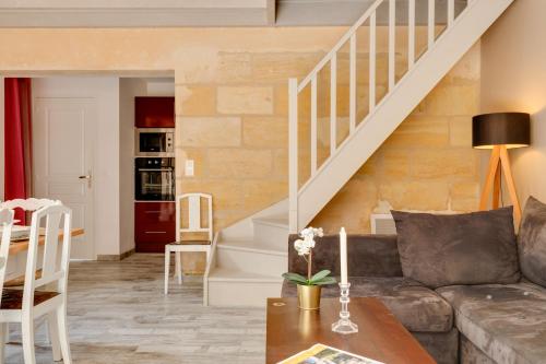 - un salon avec un canapé et des escaliers dans l'établissement La Longere Chateau Vieux Mougnac, à Petit-Palais-et-Cornemps