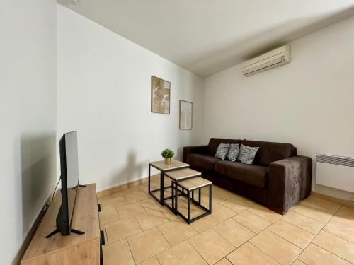 a living room with a couch and a table at Chaleureux Appartement RDC 49 m2 avec Jardin in Aix-en-Provence