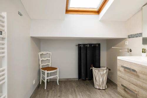 a bathroom with a sink and a chair in a room at La Longere Chateau Vieux Mougnac in Petit-Palais-et-Cornemps