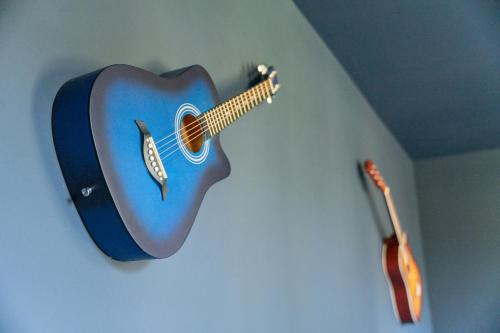 a blue guitar hanging on a wall next to a guitar at The Music Suites in Bruges