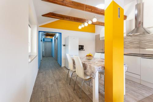 a kitchen with a table and chairs and a yellow wall at Apartma Majdas in Loka pri Mengšu