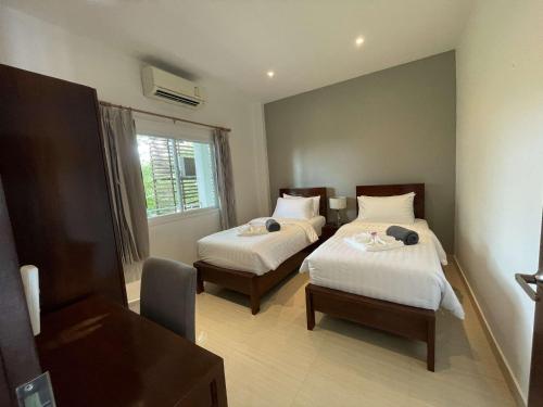 a hotel room with two beds and a window at 2 Bedroom Seaview Lanta Sport Resort 303 in Phra Ae beach