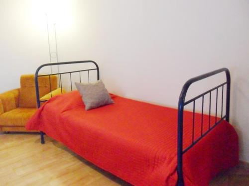 a bedroom with a red bed and a chair at Casa da Prainha 4 in São Caetano