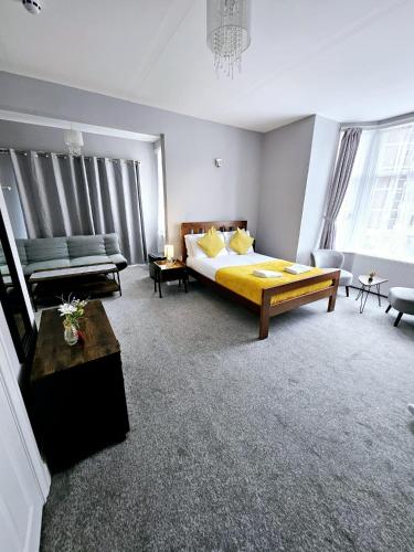 a large room with a bed and a couch and a couch at A-N-G Apartments - Parking EV 22kW by the Beach, Canoe Lake & South Parade Pier in Portsmouth
