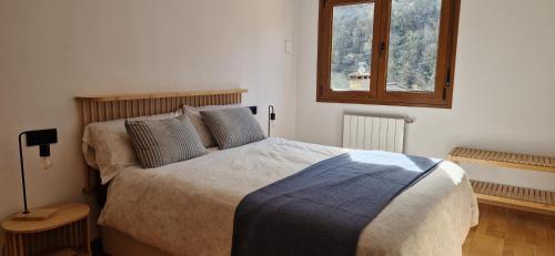 a bedroom with a large bed and a window at Apartamento Vega del Cares by Casas de Los Picos in Arenas de Cabrales