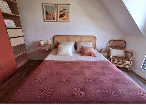 a bedroom with a large bed with a red rug at Les Ganivelles in Belz