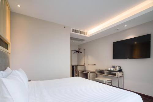 a hotel room with a bed and a flat screen tv at T2 The Portal Sukhumvit in Bangkok