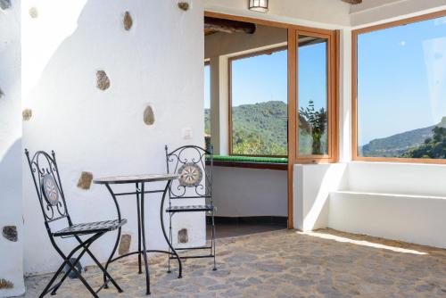 a table and two chairs in a room with a window at Quinta entre palmeras in Santa Brígida