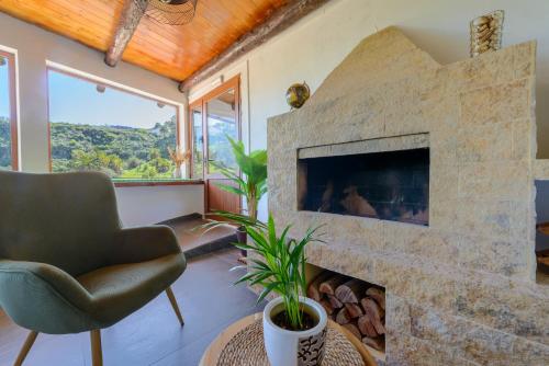 a living room with a stone fireplace and a chair at Quinta entre palmeras in Santa Brígida