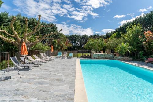 une piscine avec chaises et parasols dans une cour dans l'établissement Domaine des Maladieres, à Vézénobres
