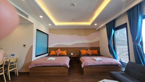 a room with two beds and a couch and a tv at Flc Sea Tower - ChillNow Căn hộ nghỉ dưỡng Quy Nhơn in Quy Nhon