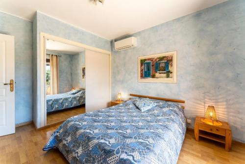 une chambre avec un grand lit et un miroir dans l'établissement Domaine des Maladieres, à Vézénobres