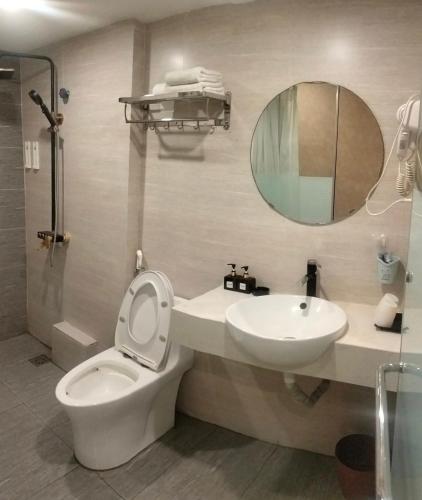 a bathroom with a toilet and a sink and a mirror at HOTEL KIS 14 Xã Đàn in Hanoi