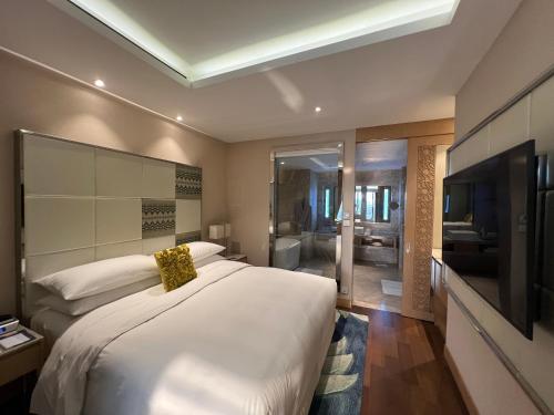 a bedroom with a large bed and a television at Renaissance Dhaka Gulshan Hotel in Dhaka
