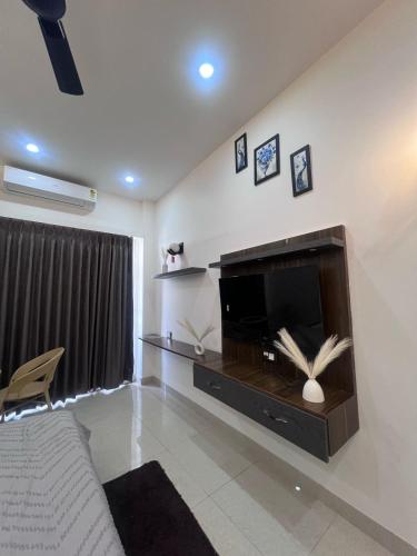 un salon avec une télévision à écran plat sur un mur dans l'établissement Gaursky studio, à Ghaziabad
