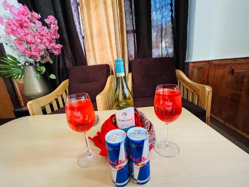 a table with two glasses and a bottle of wine at Hotel Brownie River View in Kasol