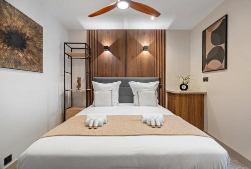 une chambre avec un grand lit blanc avec un ventilateur de plafond dans l'établissement Parc des Expositions - Cosy studio, à Paris