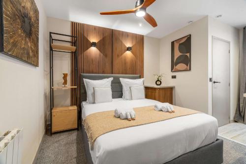 une chambre avec un grand lit blanc avec un ventilateur de plafond dans l'établissement Parc des Expositions - Cosy studio, à Paris