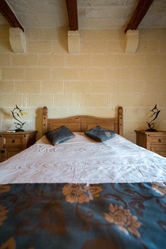 a bedroom with a bed with two pillows on it at 5 Bedroom Holiday Farmhouse with Private Pool in Għarb