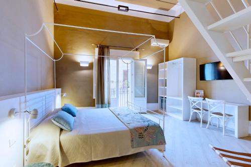 a bedroom with a large bed and a desk at Aegusa Hotel in Favignana