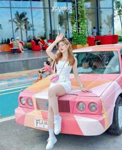 a woman sitting on the hood of a car at Flamingo Hai Tien in Nam Khê