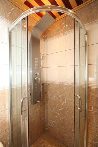a shower with a glass door in a bathroom at RAP Appart 302 avec piscine in Douala