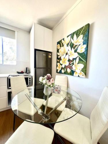 a living room with a glass table and white chairs at North Sydney Studio with Car Park AC in Sydney
