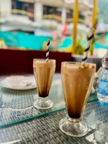 two glasses of iced coffee sitting on a table at Hotel Brownie River View in Kasol