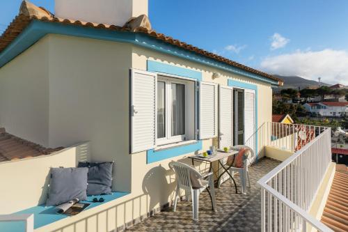 a balcony of a house with a table and chairs at Fontinha by An Island Apart in Porto Santo