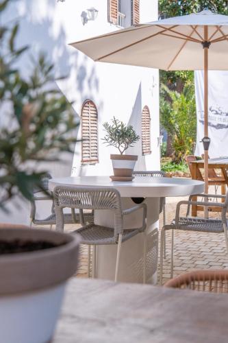 a table and chairs with an umbrella on a patio at La Bâtisse en Blanc in Golfe-Juan