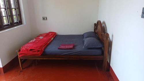a small bed in a corner of a room at Aiswarya hill stay tholpetty in Kutta
