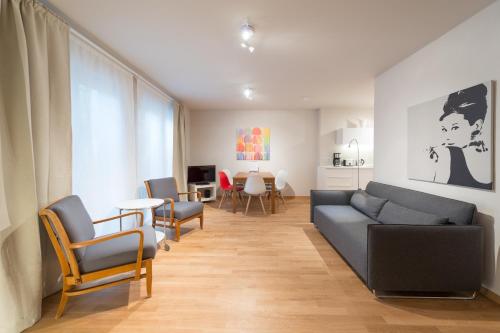 a living room with a couch and chairs and a table at Premium Apartments Thommen in Nürnberg
