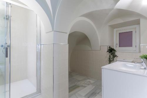 a white bathroom with a shower and a sink at Catedral Moderno Centro in Jerez de la Frontera