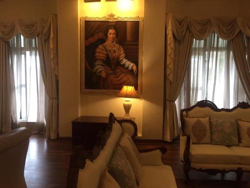a living room with a painting of a man on the wall at Grand Bungalow Nuwara Eliya by Seven Angels in Nuwara Eliya