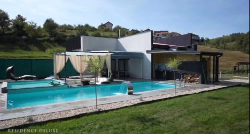a swimming pool in front of a house at Residence Deluxe Ljubijankici in Ljubijankići