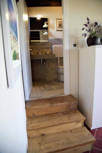 a bathroom with a toilet and a wooden staircase at Villa Trinacria in Agrigento