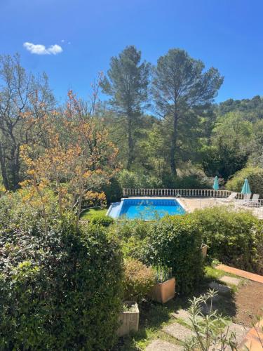 une piscine dans un jardin avec des buissons et des arbres dans l'établissement Stunning family villa with pool, à Figanières