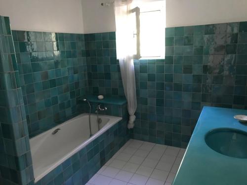La salle de bains est pourvue de carrelage vert, d'une baignoire et d'un lavabo. dans l'établissement Stunning family villa with pool, à Figanières