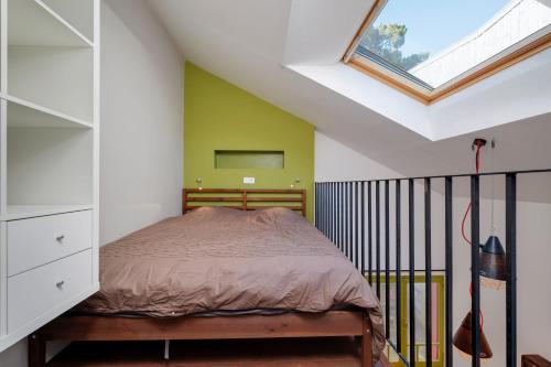 a bedroom with a bed and a skylight at Villa Etchola - Moutchic -3 étoiles in Lacanau
