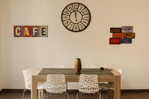 une salle à manger avec une table et une horloge au mur dans l'établissement Hype-Center Balcony 3BR AC Near Tram for6 guests, à Nice