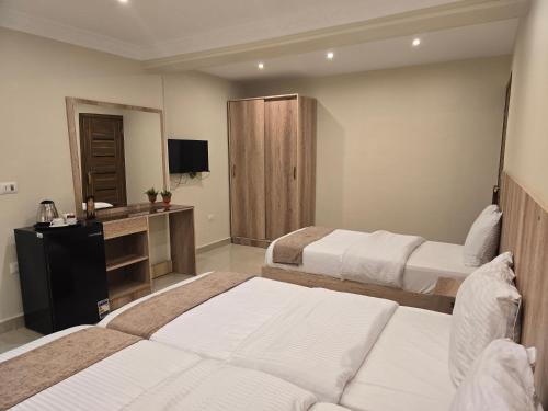a hotel room with two beds and a television at The Heaven Pyramids View in Cairo