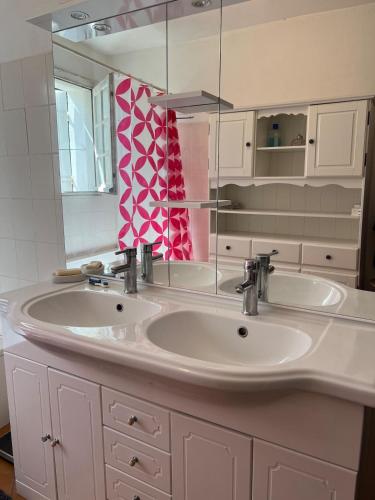 une salle de bain avec deux lavabos et un miroir dans l'établissement Grande maison de vacances, à Saint-Georges-dʼOléron