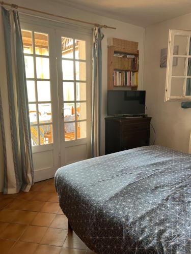 une chambre avec un lit et une porte coulissante en verre dans l'établissement Grande maison de vacances, à Saint-Georges-dʼOléron